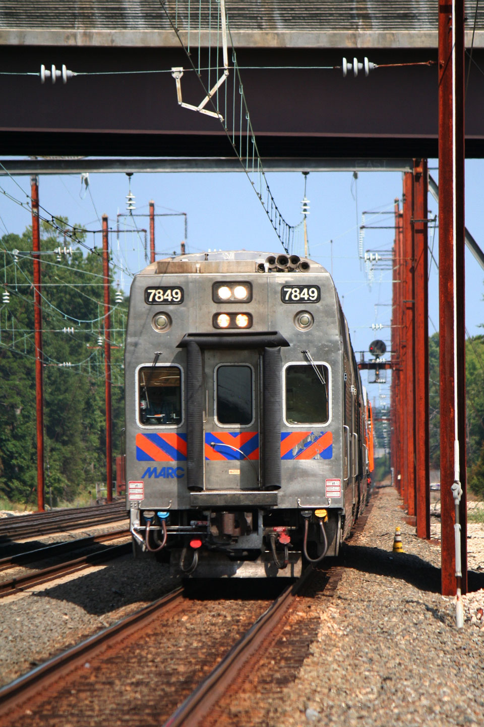 A cab car leads a mid day train into the station for its first stop.