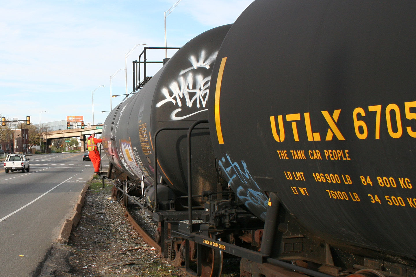 The conductor guides the shove move from the end of the first tank car.