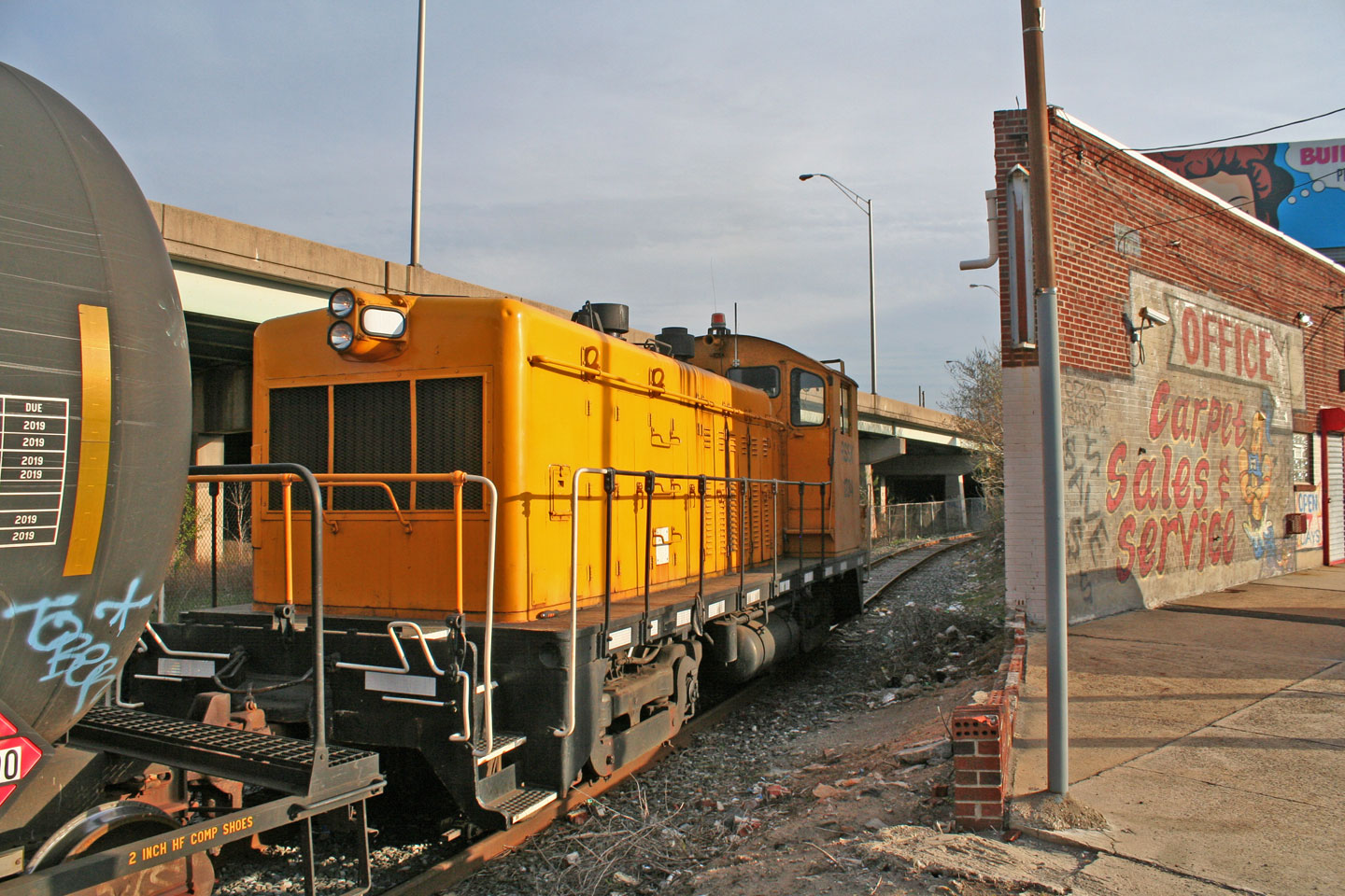 Railserve 1234 comes into view behind the oddly shaped carpet company on Aramingo Avenue.